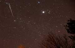 In this Dec. 13, 2012, file photo, a meteor streaks across the sky during the annual Geminid meteor shower over Springville, Ala. AP Photo/AL.com, Mark Almond