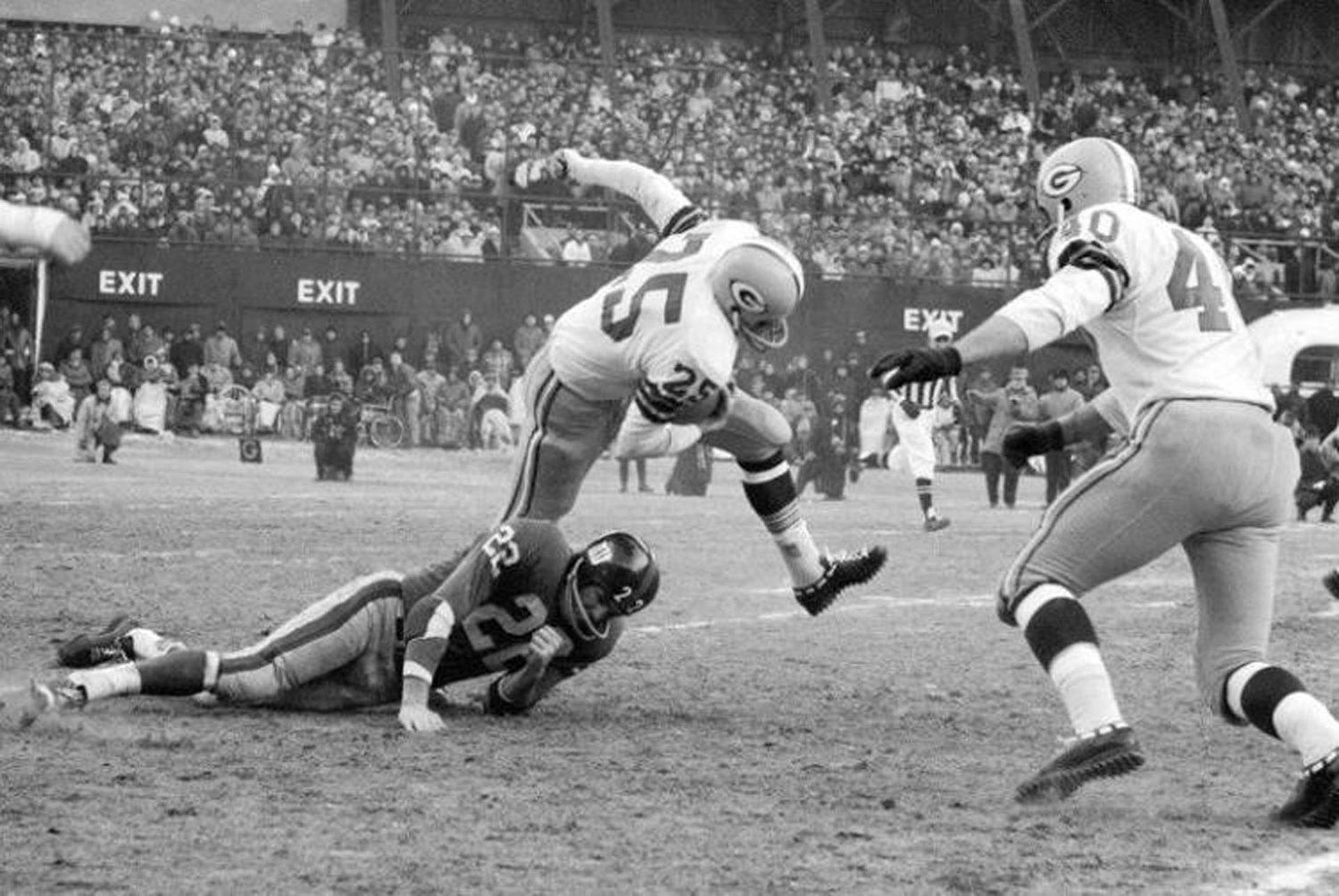 In this Dec. 30, 1962, file photo, Green Bay Packers halfback Tom Moore (25) is stopped by New York Giants` Dick Lynch (22) after returning a kickoff 30 yards in third quarter of the NFL Championship game at New York`s Yankee Stadium. Green Bay won 16-7. (AP Photo/File)