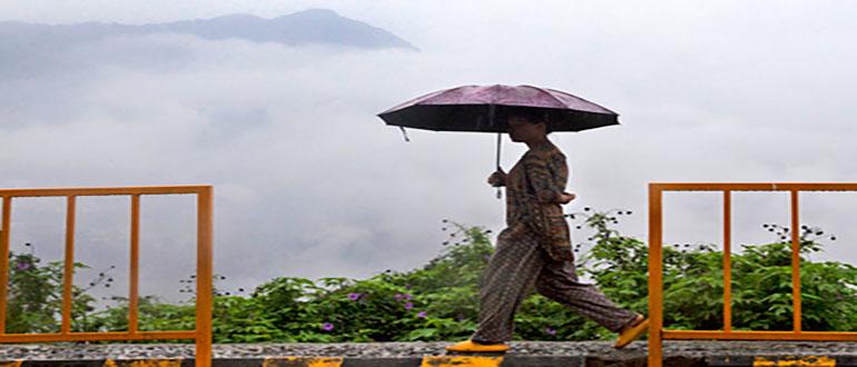 A woman holds an umbrella and walks in the rain in Kohima, capital of the northeastern India state of Nagaland, Monday, May 16, 2022. Officials in India say at least eight people have died in floods and mudslides triggered by heavy rains in the country's northeast region. (AP Photo/Yirmiyan Arthur)