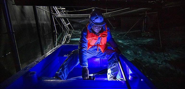 Chinese astrophysicist Cao Zhen navigates a boat across a water-filled cavern with 3,120 submerged globes with sensors used to detect Cherenkov light at the Large High-Altitude Air Shower Observatory (LHAASO) near Daocheng in southwestern China's Sichuan Province, Friday, Nov. 8, 2019. (Mark Schiefelbein, AP)