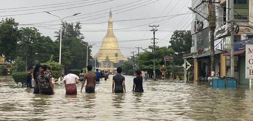 Local residents wade through a flooded road near Shwe Maw Taw pagoda in Bago, about 80 kimlometers (50 miles) northeast of Yangon, Myanmar, Monday, Oct. 9, 2023. (AP Photo/Thein Zaw)
