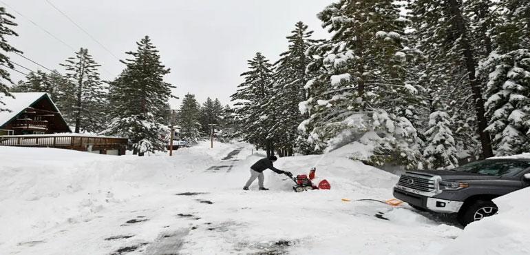 Pat Setter works on digging out his trash container outside his home at Donner Lake on Friday, March 4, 2024, in Truckee, Calif. (AP Photo/Andy Barron)
