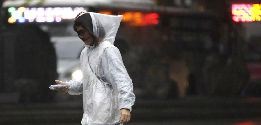A woman walks in the rain in Taipei as Typhoon Koinu approaches Taiwain, Wednesday, Oct, 4, 2023. (AP Photo/Chiang Ying-ying)