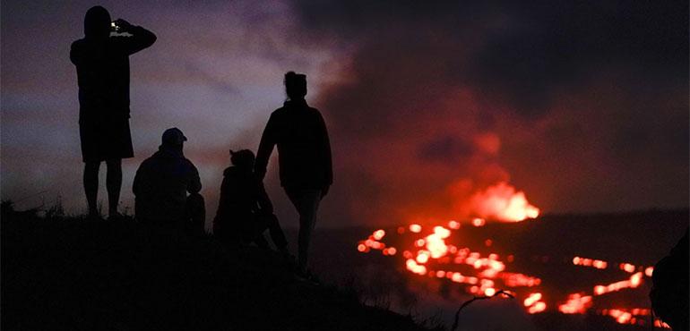 People watch lava from the Mauna Loa volcano Thursday, Dec. 1, 2022, near Hilo, Hawaii. (AP Photo/Gregory Bull, File)