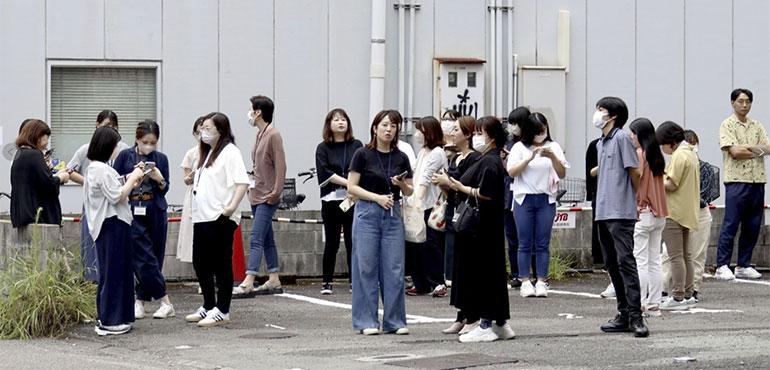 People take shelter outside building following an earthquake in Miyazaki, western Japan, Thursday, Aug. 8, 2024. (Kyodo News via AP)