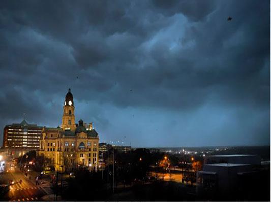 Debris flies through the air as howling winds accompanied by a line of storms approach the old Tarrant County Courthouse in downtown Fort Worth, Texas, on March 2, 2023. (Tom Fox/The Dallas Morning News via AP)
