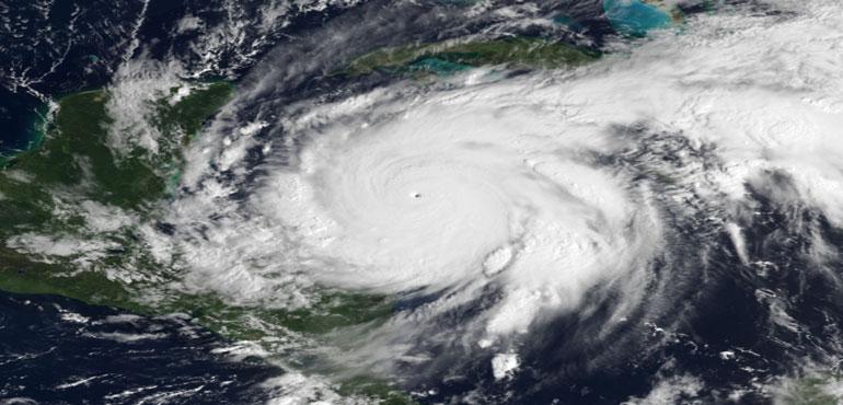 Composite image of Hurricane Wilma superimposing a visible satellite image of Wilma from GOES-12 taken at 13:45 UTC on October 19 (data from NOAA CLASS) and the October Blue Marble Next Generation data derived from MODIS imagery courtesy of Wikimedia Commons