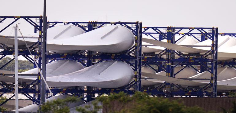 FILE - Giant wind turbine blades for the Vineyard Winds project are stacked on racks in the harbor, July 11, 2023, in New Bedford, Mass. (AP Photo/Charles Krupa, File)