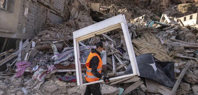 A volunteer helps savage furniture from homes which were damaged by the earthquake, in the town of Imi N'tala, outside Marrakech, Morocco, Wednesday, Sept. 13, 2023. (AP Photo/Mosa'ab Elshamy)