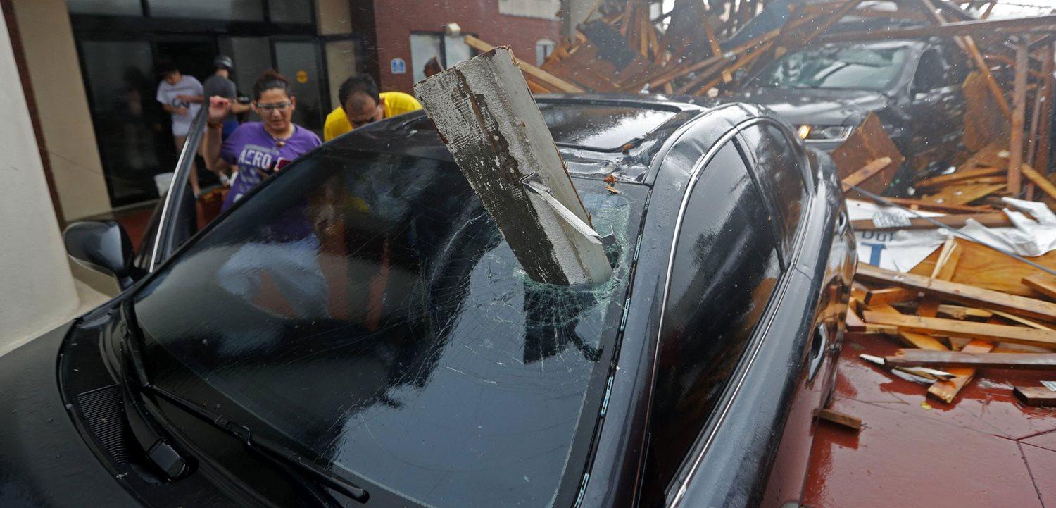 A woman checks on her vehicle as Hurricane Michael passes through, after the hotel caopy had just collapsed in Panama City, Fla., Wednesday, Oct. 10, 2018. (AP Photo/Gerald Herbert)