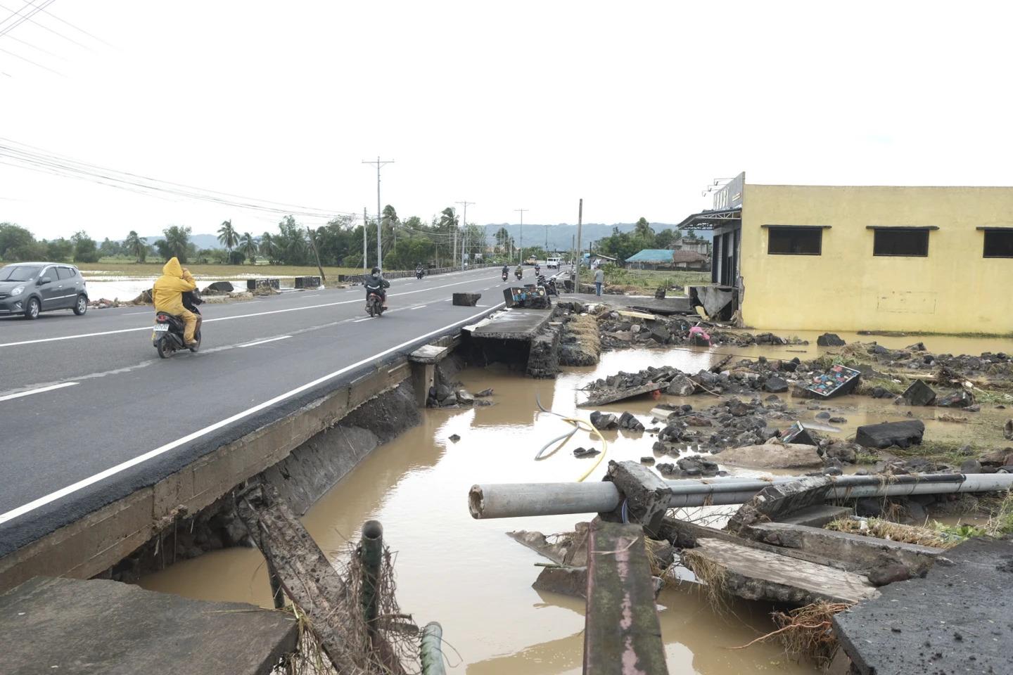 Debris from a damaged road and electric posts caused by Tropical Trami, locally named Kristine, in Polangui, Albay province, Philippines on Oct. 23, 2024. (AP Photo/John Michael Magdasoc)