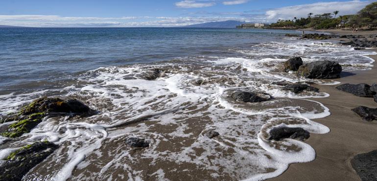 The tide circulates around rocks as it rises at Wahikuli Wayside Park on Friday, Nov. 3, 2023, in Lahaina, Hawaii. (AP Photo/Mengshin Lin, File)