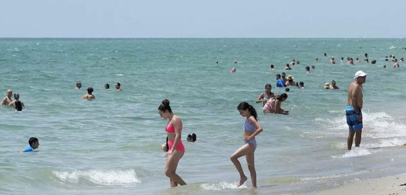 Beach goers take a dip in the Atlantic Ocean at Hollywood Beach, Monday, July 10, 2023, in Hollywood, Fla. (AP Photo/Wilfredo Lee)
