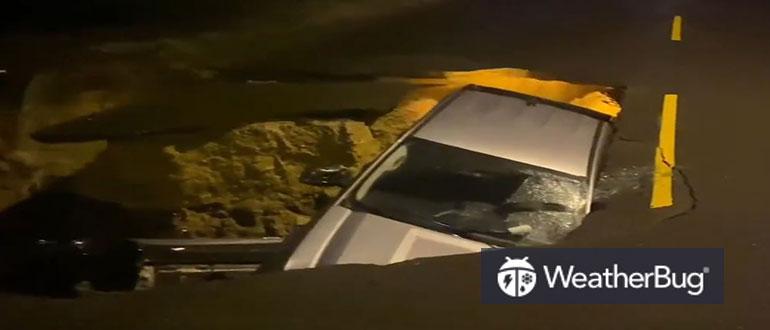 A car is seen buried in a sinkhole in Los Angeles on Monday, January 9, 2023. (Credit: LAFD PIO Erik Scott via Storyful)