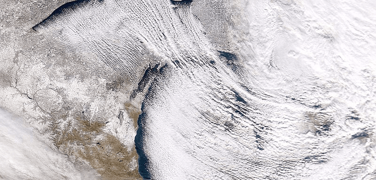 Bands of lake-effect snow are flowing off lakes Superior and Michigan, bringing snow to Michigan, in the NASA satellite file image. (NASA, Wikimedia Commons)
