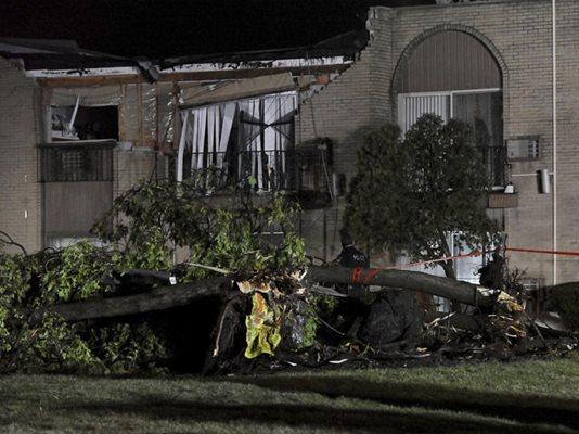 A large uprooted tree lays in the yard as first responders search and secure an apartment building on Washington Blvd., south of Hawley St. in Mundelein, Ill., Wednesday, Feb. 28, 2024, that sustained storm damage. (John Starks/Daily Herald via AP)