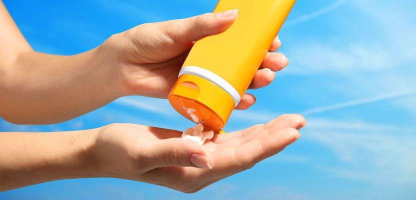 Female hands with sun protection cream on sky background. (Africa Studio via Shutterstock)