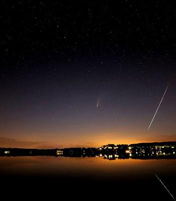 The brightest comet of the 2020 year C/2020 F3 (NEOWISE) and the bright meteor from alpha Capricornids meteor shower, whose parent body is the comet 169P/NEAT. The image is taken in the evening July 20, 2020, above the lake Wörthsee, Bayern. (Wikimedia Commons)