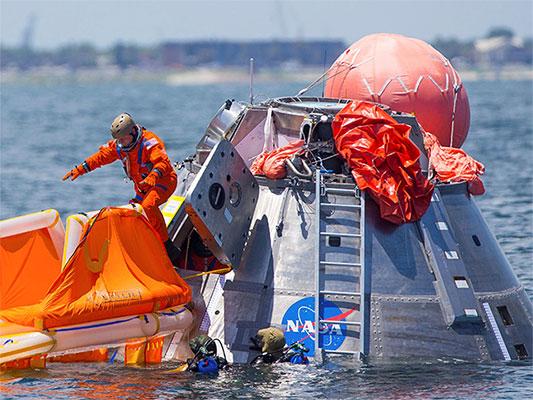 In this July 13, 2017, file photo, NASA astronaut Mike Fincke jumps into a life raft from an Orion capsule the astronauts are using for a recovery test about four miles off of Galveston Island, Texas in the Gulf of Mexico.