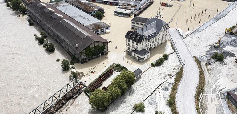 A view of the Rhone River, at left, and the Navizence River overflowing in the industrial zone that produces aluminum "Constellium," following the storms that cause major flooding, in Chippis, Switzerland, Sunday, June 30, 2024. (Olivier Maire/Keystone via AP)