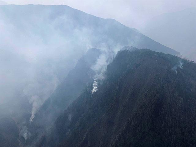 In this aerial photo released by Xinhua News Agency, smoke can be seen from a forest fire in Yalongjiang township of Muli County, Liangshan Yi Autonomous Prefecture in southwestern China's Sichuan Province on Monday, April 1, 2019. The fire high in the mountains of western China's Sichuan province has killed over two dozen firefighters and others, the government said Monday. (Courtesy of the AP)
