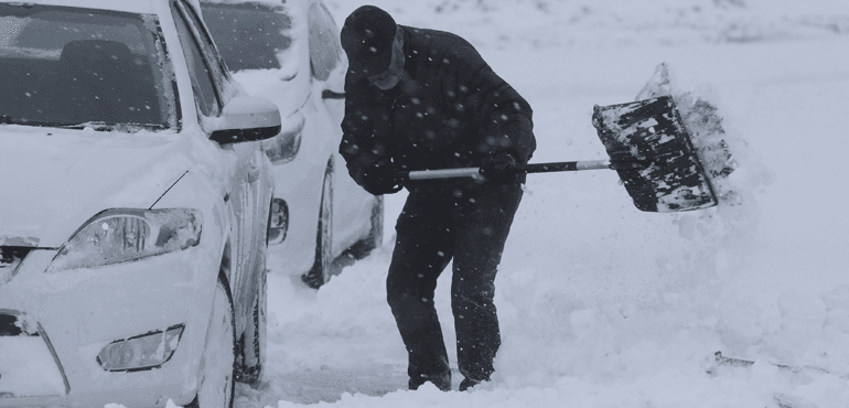 A man clears snow from a car in Larbert, Scotland, Thursday March 1, 2018. Persistent snow and freezing conditions are causing delays in many parts of Britain, with roads and train service hit particularly hard. Emergency officials said many drivers had to be rescued from stranded vehicles. (Andrew Milligan/PA via AP)
