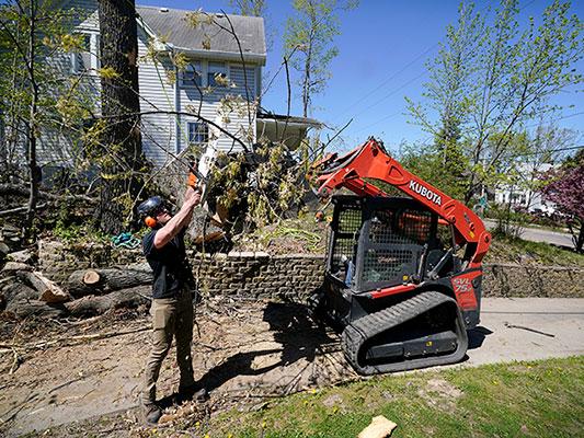Austin Even clears branches from in front of a home, Friday, April 30, 2021, in Cedar Rapids, Iowa. (Charlie Neibergall, AP)