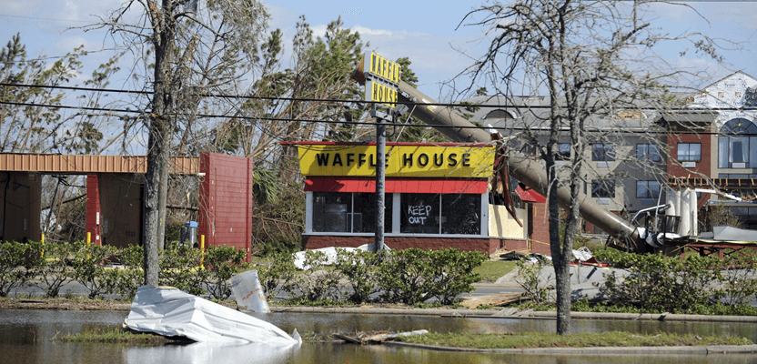 In this Sunday, Oct. 14, 2018, photo, a billboard lies atop a Waffle House restaurant after being knocked down by Hurricane Michael, in Panama City, Fla. (Carlos R. Munoz/Sarasota Herald-Tribune via AP)