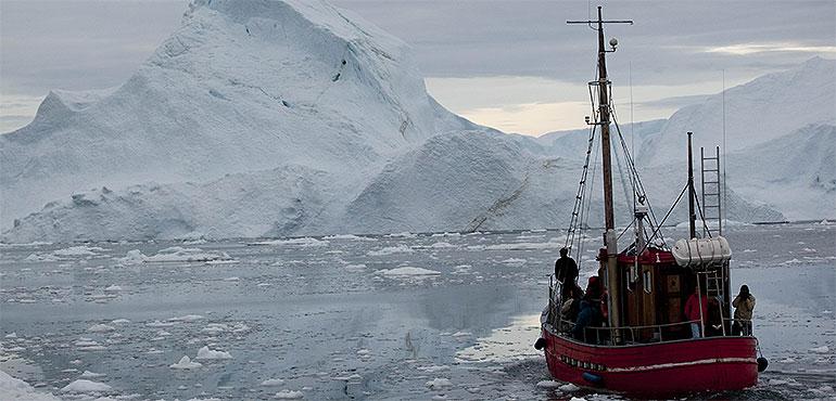 In this July 18, 2011 file photo, a boat steers slowly through floating ice, and around icebergs, all shed from the Greenland ice sheet, outside Ilulissat, Greenland. (Brennan Linsley, AP)