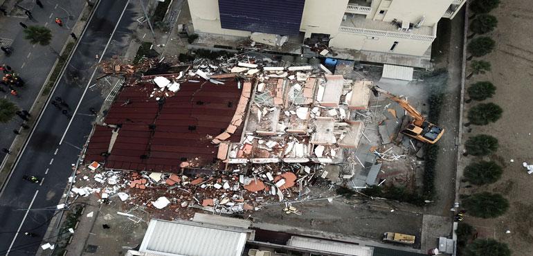 A bulldozer operates after a remote-controlled explosion to demolish a building in the western port city of Durres, Albania, Tuesday, Dec. 3, 2019. A remote-controlled explosion has demolished the six-storied building considered threatening after being damaged from the 6.4 magnitude earthquake in Albania.(Hektor Pustina/AP)