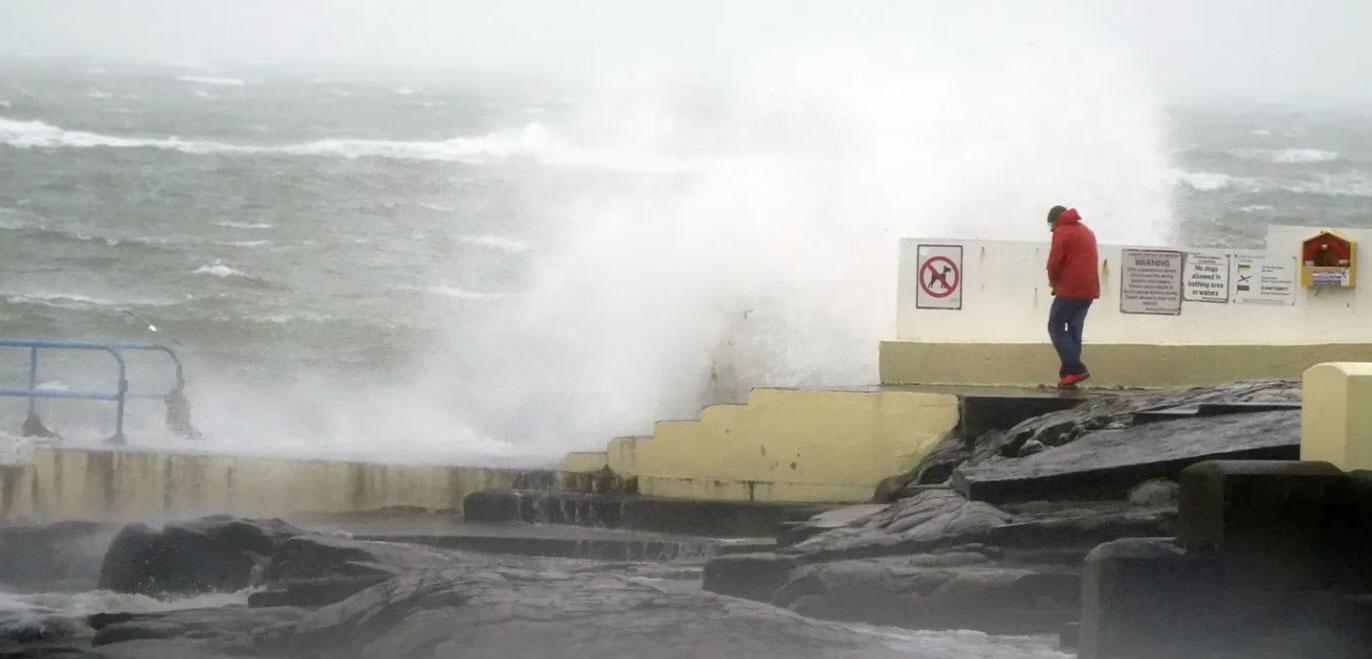 A person looks at high waves in Salthill, Galway, Ireland, Sunday, Jan. 21, 2024, during storm Isha. (Niall Carson/PA via AP)
