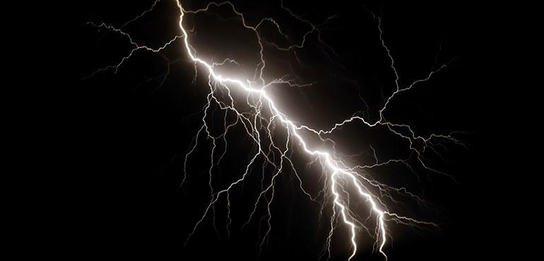 Lightning bolts isolated on black, capturing nature's force, shallow depth of field. (Henrik A. Jonsson via Shutterstock)