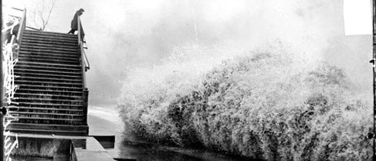 Image: View of wave breaking on the shore of Lake Michigan by Lincoln Park in Chicago, Illinois, while a man watches from High Bridge. (Chicago Daily News, Inc.)